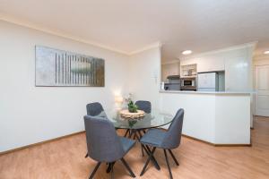 a dining room with a glass table and chairs at Surfers Tradewinds in Gold Coast