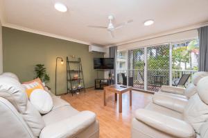 a living room with white furniture and a large window at Surfers Tradewinds in Gold Coast