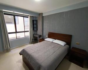 a bedroom with a large bed and a window at Hotel Virgen de las Peñas 2 in Oruro