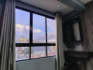 a room with a window with a view of a city at Hotel Virgen de las Peñas 2 in Oruro