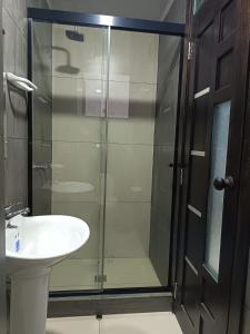 a bathroom with a glass shower and a sink at Hotel Virgen de las Peñas 2 in Oruro +8 photos