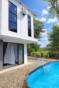 a house with a swimming pool in front of it at Cabaña Moderna a 1km del Centro de Tauramena in Tauramena