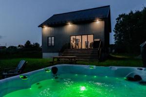 a bath tub in front of a small house at Batiscan - Waterfront Private Spa & Sauna in Saint Adelphe