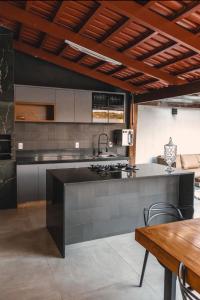 a kitchen with a large counter and a table at Casa Malta Goiânia in Goiânia