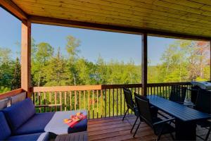 a screened in porch with a table and chairs at L'Enchanteur - Private Spa & Pet Friendly in Pohénégamook