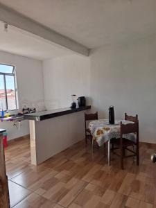 a kitchen with a table and a table and chairs at Suite confort 02 in Contagem +22 photos