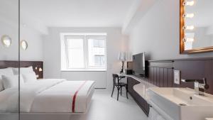 a bedroom with a bed and a bathroom with a sink at Ruby Lissi Hotel Vienna by IHG in Vienna
