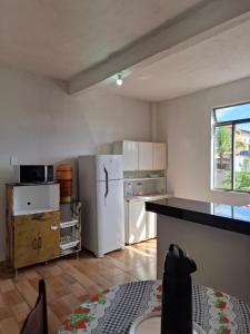 a kitchen with a white refrigerator and a window at Suite confort 02 in Contagem
