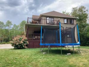 a house with a playground in front of a house at L'Escapade - Spa billard & foyer in Petite-Rivière-Saint-François