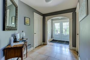 a hallway with a desk and a door with a mirror at L'Escapade - Spa billard & foyer in Petite-Rivière-Saint-François