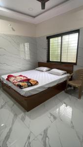 a bedroom with a bed and a chair in it at VISHNU DATTA HOMESTAy in Bandanwāda