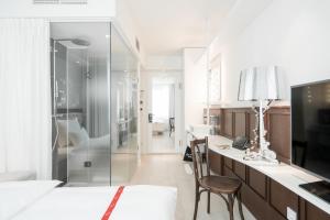 a large white room with a desk and a television at Ruby Lissi Hotel Vienna by IHG in Vienna