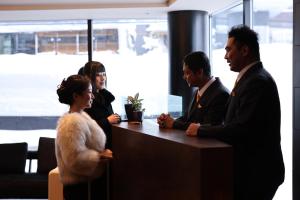 a group of people standing around a desk at HOTELA Niseko Towers in Kutchan