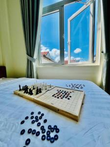 a chess board on a bed in front of a window at Punica Homestay in Tuy Hoa +15 photos