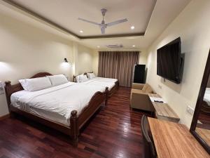 una habitación de hotel con cama y televisor de pantalla plana en Prince Hotel Chiang Mai, en Chiang Mai
