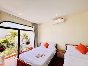 a bedroom with two beds and a large window at Punica Homestay in Tuy Hoa