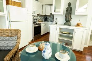 a kitchen with a glass table with two cups on it at Dungeness Barn House Bed and Breakfast at Two Crows Farm in Sequim
