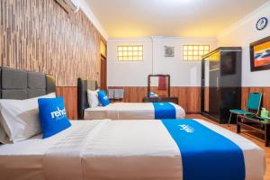 a hotel room with two beds and a desk at Rehat at Hotel Sabang in Bandung +51 photos