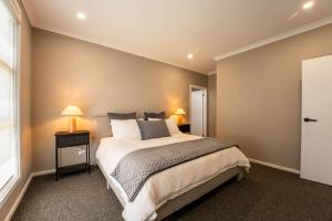a bedroom with a large bed and two lamps at 10 Jefferson Court in Wellington East +18 photos