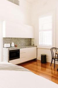 a white kitchen with a counter and a window at The Brewers House in Beechworth