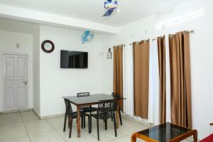 a living room with a table and a tv at Blooms home stay in Thekkady