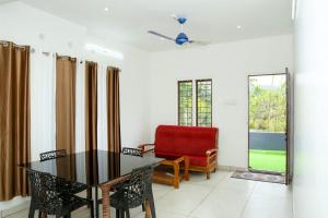 a living room with a table and a chair at Blooms home stay in Thekkady