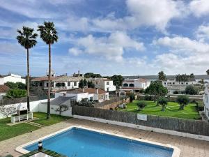 a swimming pool in a yard with houses at Apartamento con piscina SS19 in Fornells