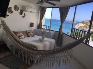 a hammock bed in a room with a view of the ocean at Apto Diners Rodadero WiFi - Piscina - Playa in Rodadero +34 photos