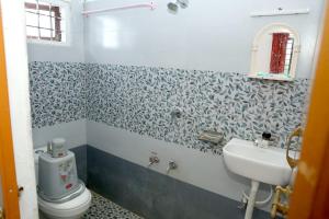 a bathroom with a toilet and a sink at Blooms home stay in Thekkady +2 photos