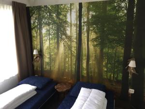 a bedroom with a wall mural of a forest at Park De Haeghehorst in Ermelo