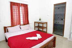 a bedroom with a bed with two towels on it at Blooms home stay in Thekkady