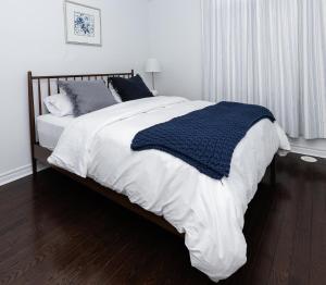 a bedroom with a bed with a blue blanket on it at Vacation Home in Vaughan in Vaughan