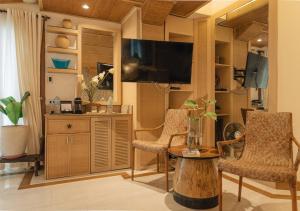 a living room with two chairs and a flat screen tv at Vivere Azure in Batangas City