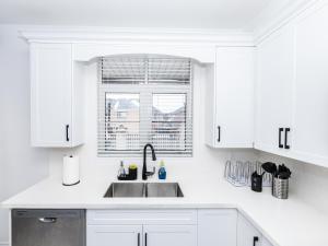 a white kitchen with a sink and a window at Vacation Home in Vaughan in Vaughan +38 photos