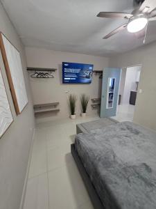 a bedroom with a bed and a flat screen tv at Latitude Adjustment in San Juan