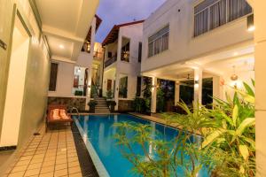 a house with a swimming pool in front of a house at Hikka Boutique in Hikkaduwa