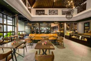a restaurant with tables and chairs and a bar at The Vira Bali Boutique Hotel & Suite in Kuta