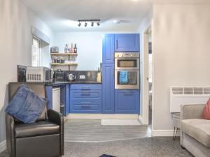 a kitchen with blue cabinets and a blue door at Corner Spot in Hednesford