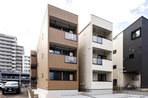 an apartment building with balconies in a parking lot at Anecis笠取町1 in Nagoya