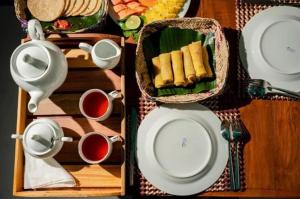 a table topped with plates and cups of tea at Breeze Climes Ella in Ella +30 photos