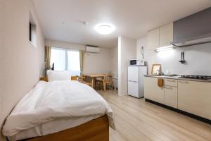 a small room with a bed and a kitchen at Anecis笠取町1 in Nagoya