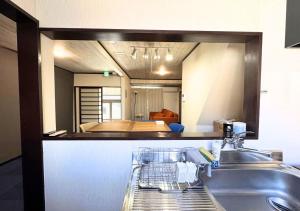 a kitchen with a sink and a bedroom in a mirror at Nishijin Stay One in Fukuoka