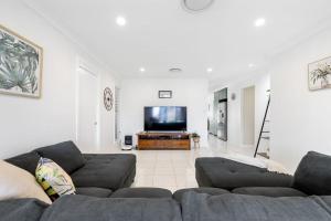 a living room with a couch and a flat screen tv at The Salty Anchor in Banksia Beach