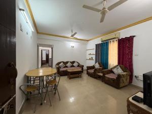 a living room with a couch and a table at Goa Homeland 3 double bed Calangute in Calangute