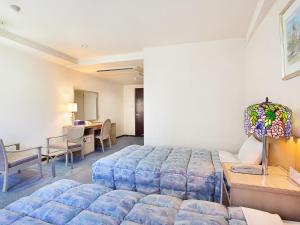 a hotel room with a bed and a desk at Hotel Luna Park in Matsuyama