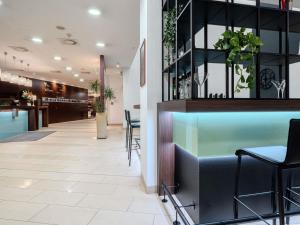 a lobby with a bar with stools and tables at Hotel Mercure Graz City in Graz