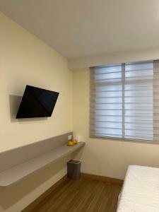 a bedroom with a flat screen tv on the wall at Serenity Homestay Penuin Batam in Batam Center +23 photos