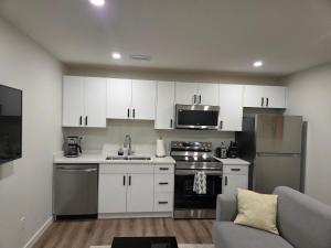 a kitchen with white cabinets and stainless steel appliances at The Heavenly Crib in Saskatoon