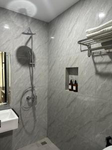a bathroom with a shower and a sink at Serenity Homestay Penuin Batam in Batam Center