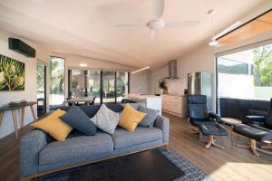 a living room with a couch and a kitchen at Gumleaf Villa Hosted by Halls Gap Accommodation in Halls Gap
